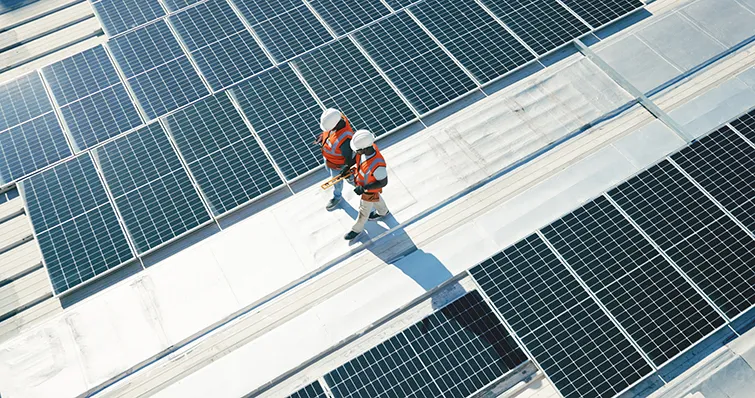 Workers on a roof with solar panels