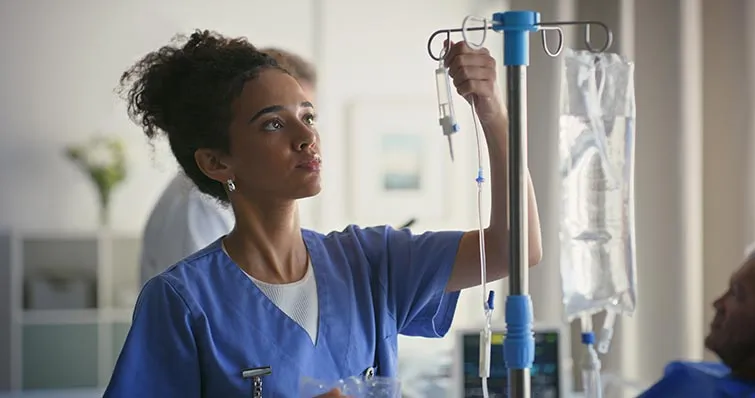 Young health care worker setting up an IV