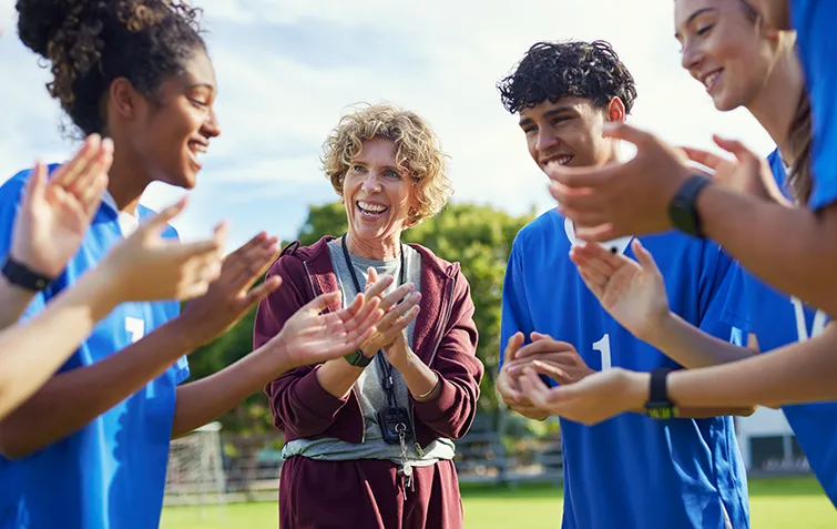 Coach celebrating outside with players
