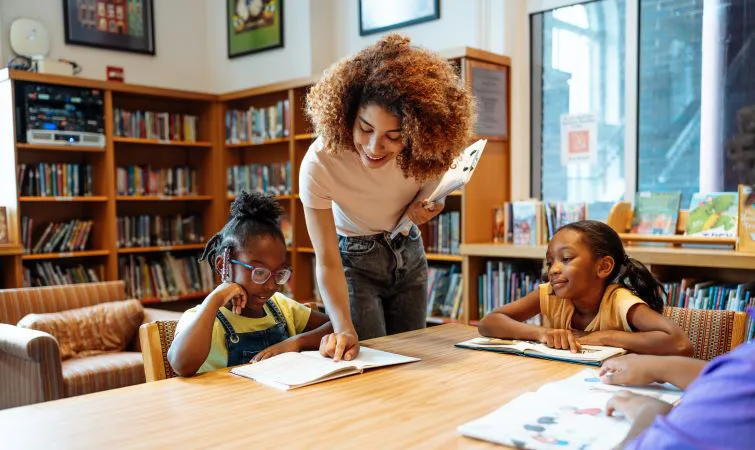 Teacher helping student in library