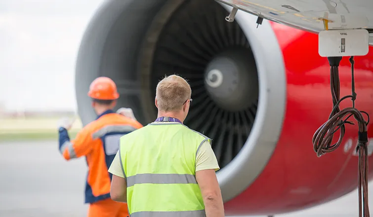 Airplane mechanics in front of an engine