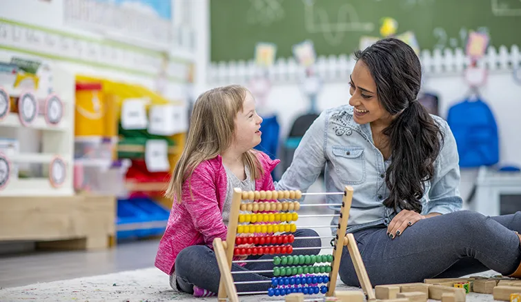 Young special education student with teacher in classroom