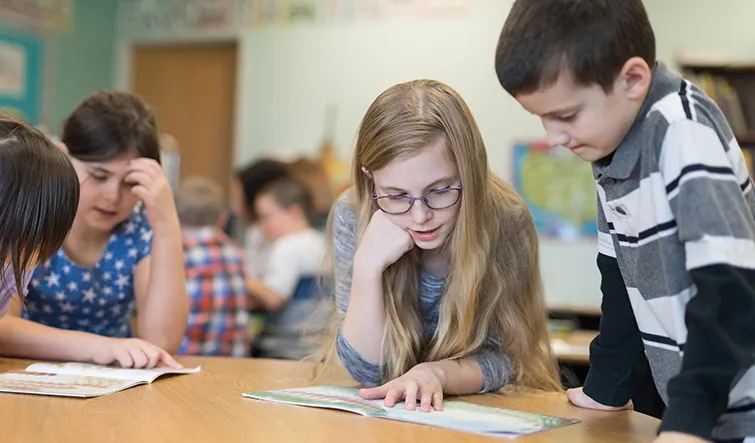 Elementary kids working together with workbooks