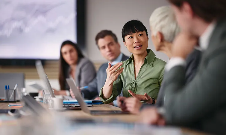 Woman speaking to colleagues in a meeting