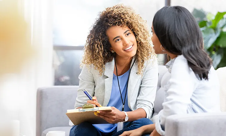 Woman with clipboard talking to colleague