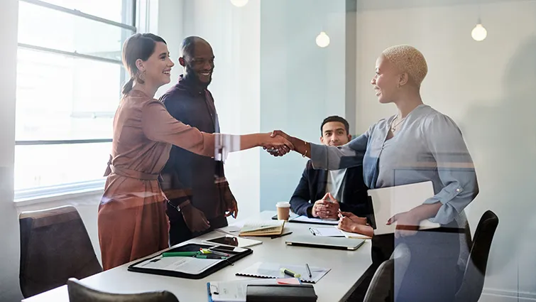 Business colleagues shaking hands in sunny room