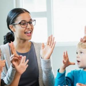 female teacher clapping hands and counting with elementary students