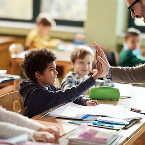 Teacher and student high-fiving