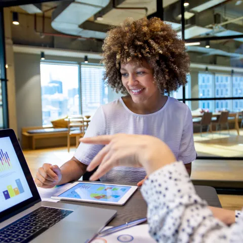 Two people looking at data on a laptop