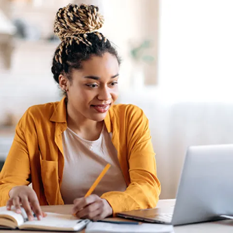 College student studying with laptop and notebook
