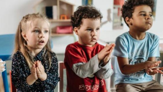 three elementary children clasping hands