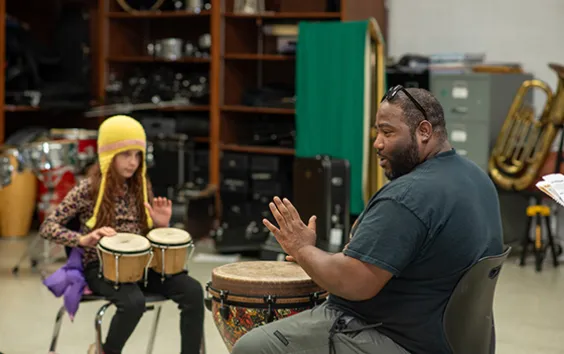 Teacher and student playing bongos
