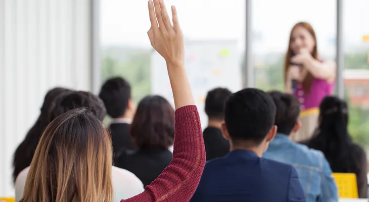 Woman raising her hand in a group