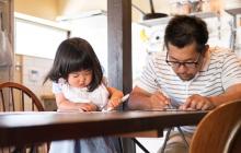 Father and daughter taking a survey at kitchen table