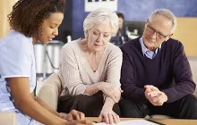 Image of older couple looking at papers with a health professional
