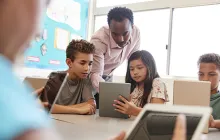 Image of teacher in classroom with students on tablets