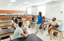 Image of socially distanced teachers in a classroom, wearing masks