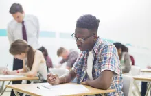 High school student studying at school desk