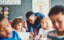 Teacher and young students on computers
