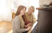 Girl at piano with instructor