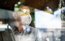 Man in mask looking out the window