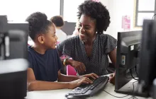Teacher and student at desktop computer