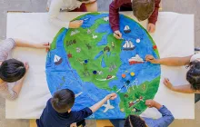 Young children painting colorful world map