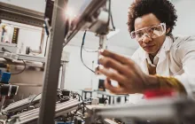Black female engineer working on industrial machine in a laboratory