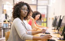 Young woman at row of computers