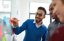 Portrait of an indian man in a diverse team of creative millennial coworkers in a startup brainstorming strategies