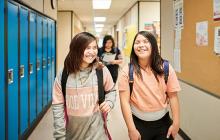 Teenage girls walking down a school hallway