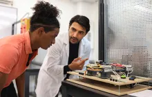 Teacher and student working on an engineering project in a classroom