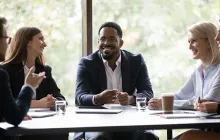Five multiethnic company staff gather together talking planning future project