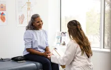 Female doctor talks to her senior adult patient about preventative lab work she should have completed
