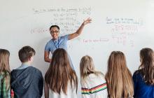 Teacher at white board with math students