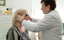 Optometrist adjusting test frame for patient