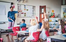 Black teacher calling on elementary students