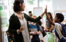 Teacher high fives an elementary student