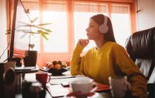 Teacher seated at computer wearing headphones