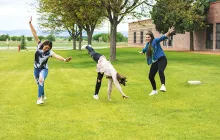 Teenage girls cartwheeling outside Colorado school