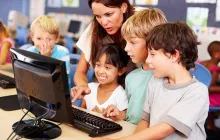 teacher working with students on a computer