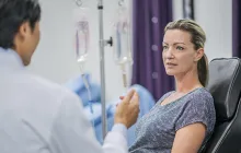 woman with iv talking to doctor