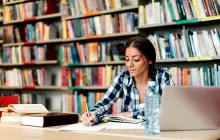 high school student doing schoolwork in library