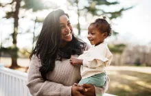 Loving mom holding baby outside