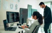 Programmers working together at multiple computers