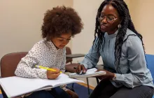 Teacher and student working together at desk