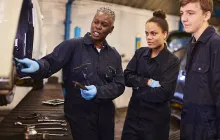 Trainer and apprentices in factory