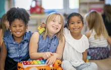 Young children hugging in a classroom