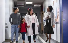 Principal with family in school hallway