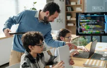 Teacher with young computer science students